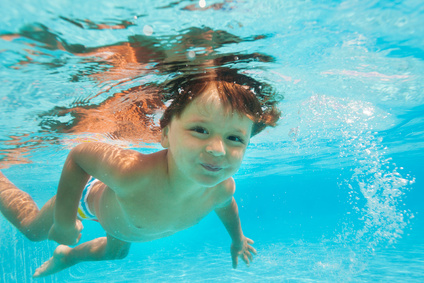 Close up view of small boy swimming under water